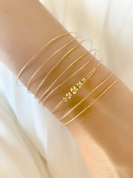 Jonc HARMONY, réalisé en plaqué or Gold filled 14 carats, est composée d'un dégradé de cinq perles rondes et lumineuses.