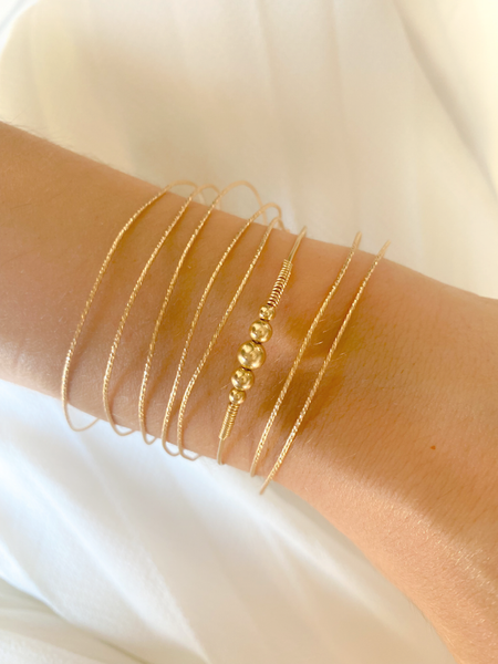 Jonc HARMONY, réalisé en plaqué or Gold filled 14 carats, est composée d'un dégradé de cinq perles rondes et lumineuses.