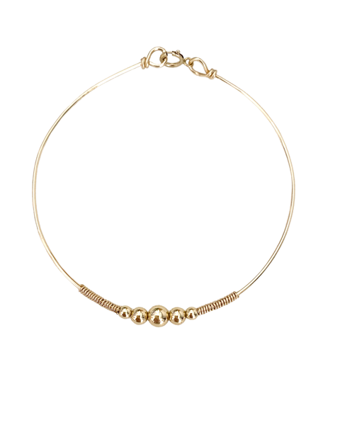 Jonc HARMONY, réalisé en plaqué or Gold filled 14 carats, est composée d'un dégradé de cinq perles rondes et lumineuses.