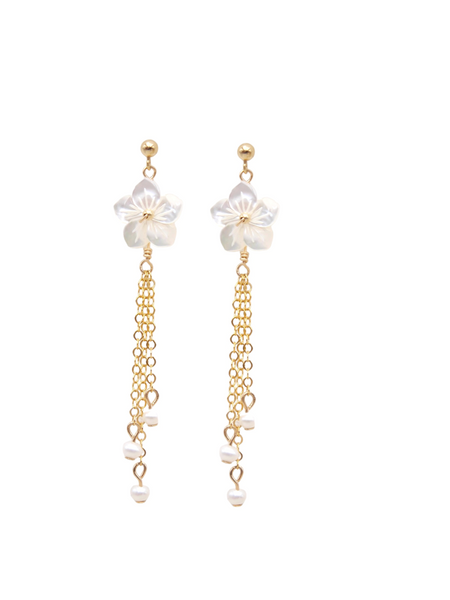 Les boucles HANAÉ, incarnent féminité et romantisme. Ces boucles d'oreilles délicates, réalisées en or laminé 585/1000* (Gold filled), se distinguent par une fleur de nacre blanche finement sculptée,