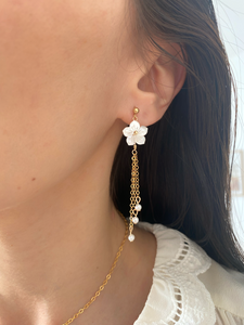 Les boucles HANAÉ, incarnent féminité et romantisme. Ces boucles d'oreilles délicates, réalisées en or laminé 585/1000* (Gold filled), se distinguent par une fleur de nacre blanche finement sculptée,