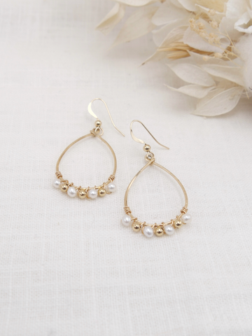 Les boucles d'oreilles NAÏADE sont une véritable invitation à la douceur et au raffinement. Réalisées en or laminé 585/1000, elles sont très légères et&nbsp;se composent de perles d'eau douce et de perles en or laminé tissées à la main.&nbsp;