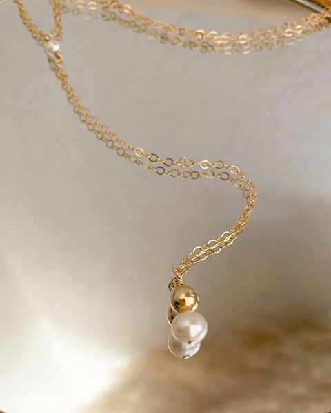 Minimaliste et bohème-chic à la fois, le collier de dos LIVIA, réalisé en Gold filled* 14 carats, est composé de perles de culture d’eau douce et de perles en or Gold filled.  