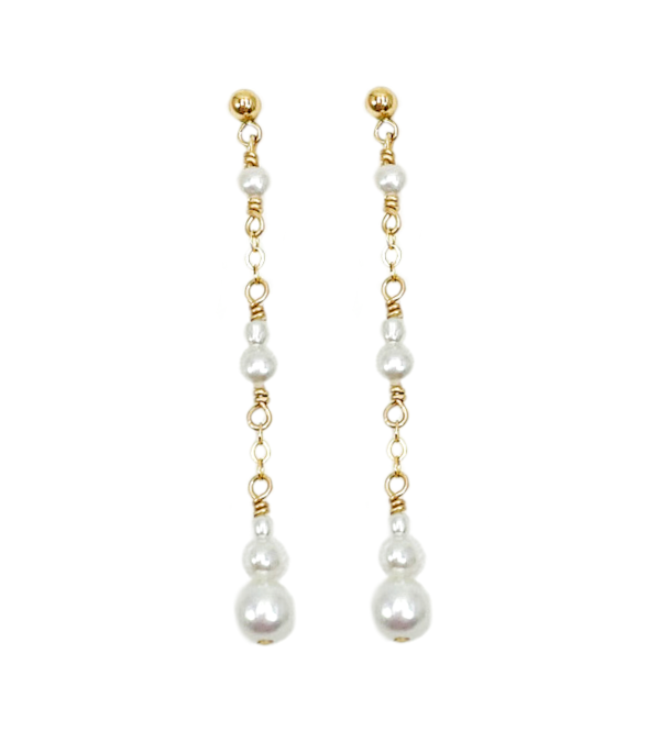 Féminines et élégantes, les boucles d'oreilles POEMA PENDANTES réalisées en plaqué or Gold filled* 14 carats, sont composées d’un dégradé de perles d'eau douce blanches et lumineuses.