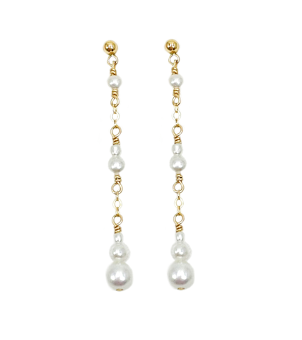 Féminines et élégantes, les boucles d'oreilles POEMA PENDANTES réalisées en plaqué or Gold filled* 14 carats, sont composées d’un dégradé de perles d'eau douce blanches et lumineuses.